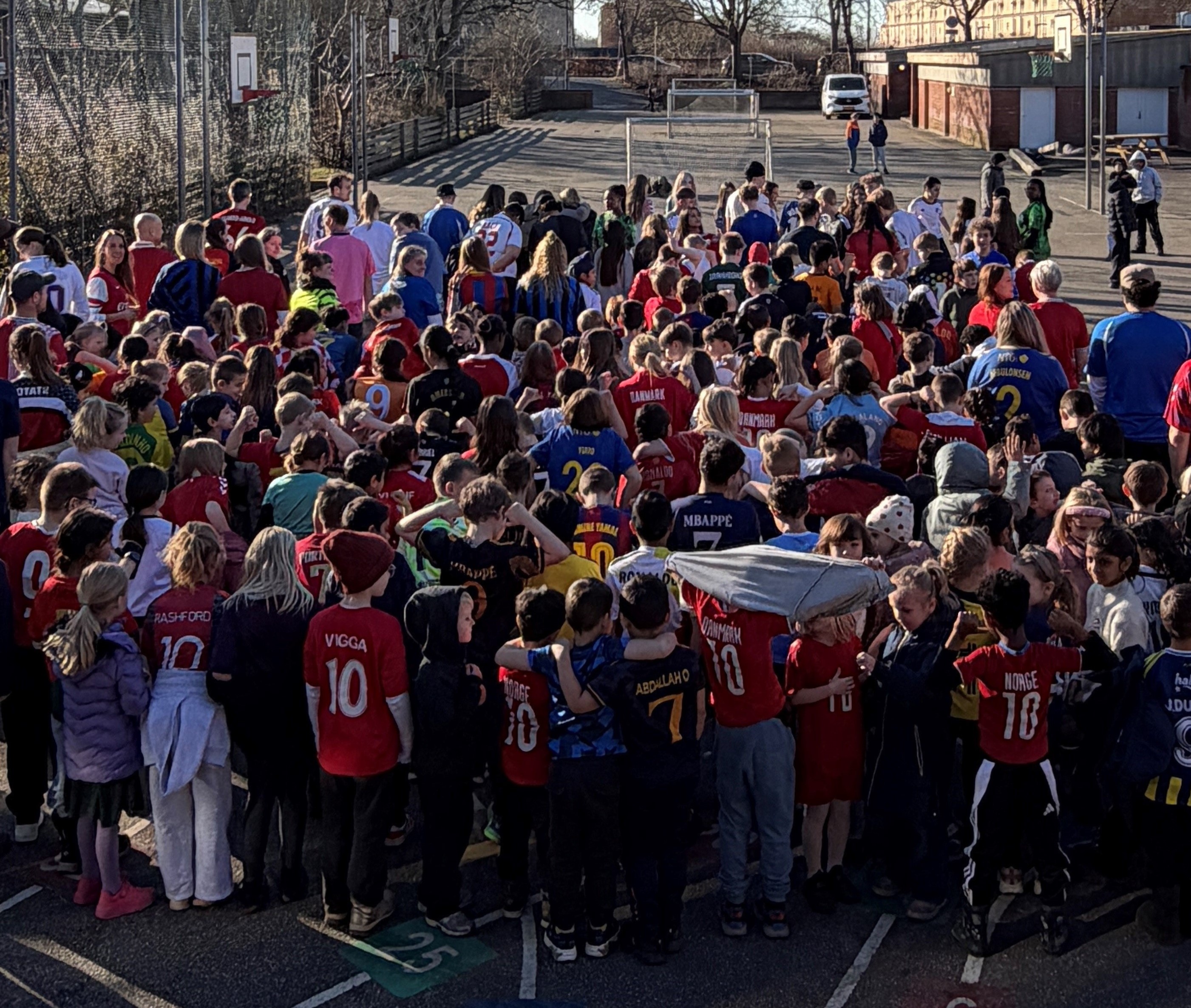 Elever i skolegården med fodboldtrøjer